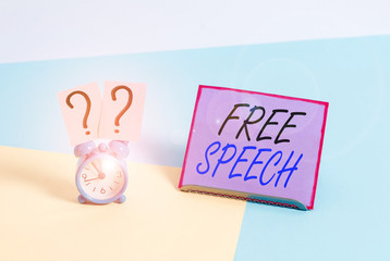 Word writing text Free Speech. Business photo showcasing the right of showing to express their opinions publicly Mini size alarm clock beside a Paper sheet placed tilted on pastel backdrop