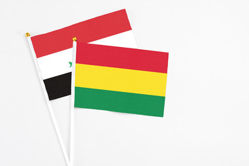 Bolivia and Iraq stick flags on white background. High quality fabric, miniature national flag. Peaceful global concept.White floor for copy space.