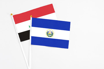 El Salvador and Iraq stick flags on white background. High quality fabric, miniature national flag. Peaceful global concept.White floor for copy space.