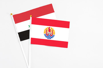 French Polynesia and Iraq stick flags on white background. High quality fabric, miniature national flag. Peaceful global concept.White floor for copy space.