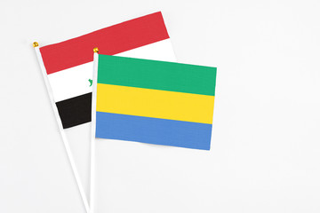 Gabon and Iraq stick flags on white background. High quality fabric, miniature national flag. Peaceful global concept.White floor for copy space.
