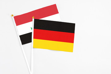 Germany and Iraq stick flags on white background. High quality fabric, miniature national flag. Peaceful global concept.White floor for copy space.