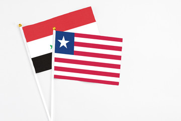 Liberia and Iraq stick flags on white background. High quality fabric, miniature national flag. Peaceful global concept.White floor for copy space.