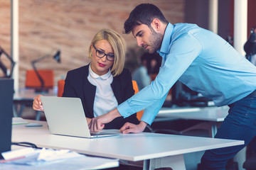Happy business partners working on laptop. Teamwork, co-working concepts.