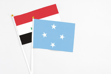 Micronesia and Iraq stick flags on white background. High quality fabric, miniature national flag. Peaceful global concept.White floor for copy space.