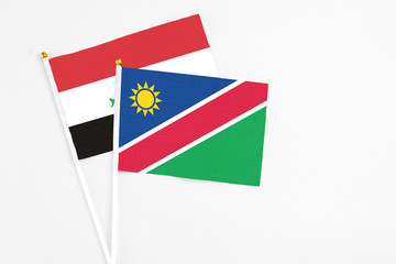 Namibia and Iraq stick flags on white background. High quality fabric, miniature national flag. Peaceful global concept.White floor for copy space.