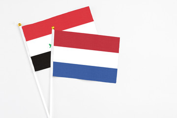 Netherlands and Iraq stick flags on white background. High quality fabric, miniature national flag. Peaceful global concept.White floor for copy space.