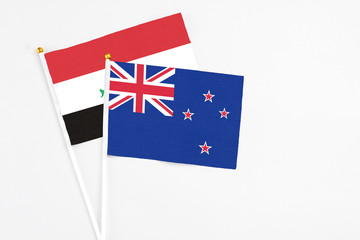 New Zealand and Iraq stick flags on white background. High quality fabric, miniature national flag. Peaceful global concept.White floor for copy space.