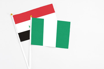 Nigeria and Iraq stick flags on white background. High quality fabric, miniature national flag. Peaceful global concept.White floor for copy space.