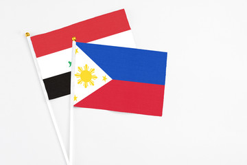 Philippines and Iraq stick flags on white background. High quality fabric, miniature national flag. Peaceful global concept.White floor for copy space.