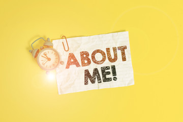 Text sign showing About Me. Business photo showcasing telling someone list of your good and bad traits and past events Metal alarm clock clip blank crushed note sheet colored background
