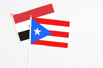 Puerto Rico and Iraq stick flags on white background. High quality fabric, miniature national flag. Peaceful global concept.White floor for copy space.