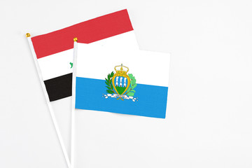 San Marino and Iraq stick flags on white background. High quality fabric, miniature national flag....