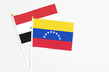 Venezuela and Iraq stick flags on white background. High quality fabric, miniature national flag. Peaceful global concept.White floor for copy space.