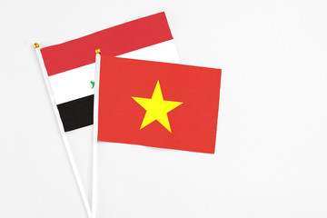 Vietnam and Iraq stick flags on white background. High quality fabric, miniature national flag. Peaceful global concept.White floor for copy space.