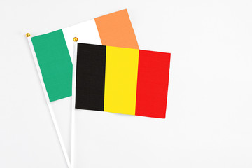 Belgium and Ireland stick flags on white background. High quality fabric, miniature national flag. Peaceful global concept.White floor for copy space