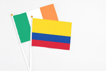 Colombia and Ireland stick flags on white background. High quality fabric, miniature national flag. Peaceful global concept.White floor for copy space