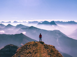 A man stands atop a mountain in the Alps in Germany