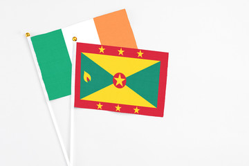 Grenada and Ireland stick flags on white background. High quality fabric, miniature national flag. Peaceful global concept.White floor for copy space