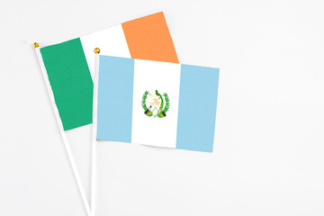 Guatemala and Ireland stick flags on white background. High quality fabric, miniature national flag. Peaceful global concept.White floor for copy space