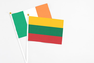 Lithuania and Ireland stick flags on white background. High quality fabric, miniature national flag. Peaceful global concept.White floor for copy space