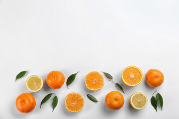 Flat lay composition with tangerines and lemons on white background. Space for text