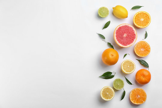 Flat lay composition with tangerines and different citrus fruits on white background. Space for text