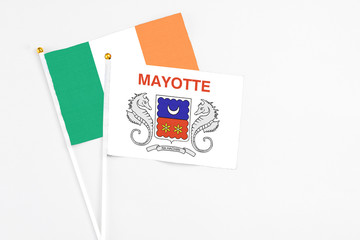 Mayotte and Ireland stick flags on white background. High quality fabric, miniature national flag. Peaceful global concept.White floor for copy space