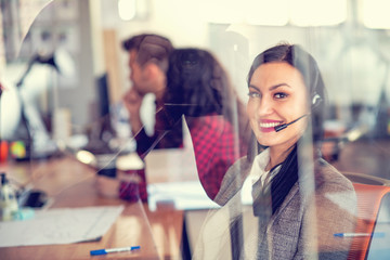 Beautiful call center agent browsing the internet on her computer