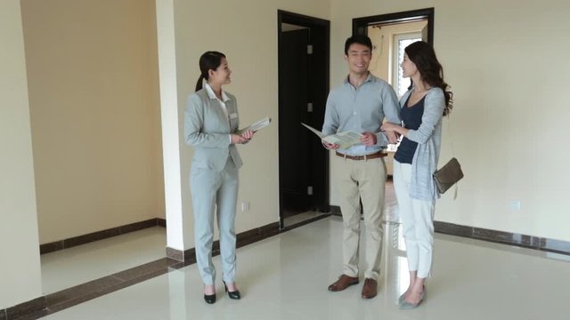Young realtor showing new house to young couple,HD
