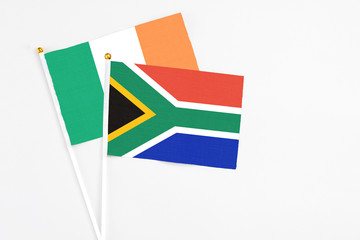South Africa and Ireland stick flags on white background. High quality fabric, miniature national flag. Peaceful global concept.White floor for copy space