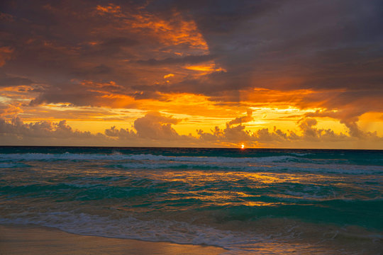 Dramatic sky during sunrise hour. Picture taken on a cloudy and windy day in November  in Cancun, Mexico over Caribbean sea.