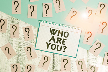 Writing note showing Who Are You Question. Business concept for Identify yourself description demonstratingal characteristics Scribbled and crumbling papers with thick cardboard above wooden table
