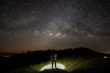 milky way in night sky over mountain with man in background