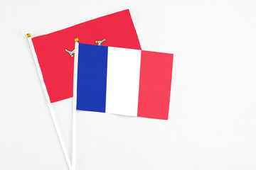 France and Isle Of Man stick flags on white background. High quality fabric, miniature national flag. Peaceful global concept.White floor for copy space.