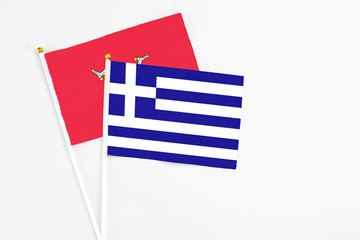 Obraz premium Greece and Isle Of Man stick flags on white background. High quality fabric, miniature national flag. Peaceful global concept.White floor for copy space.