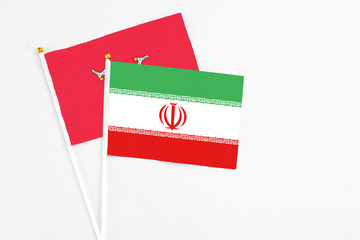 Iran and Isle Of Man stick flags on white background. High quality fabric, miniature national flag. Peaceful global concept.White floor for copy space.