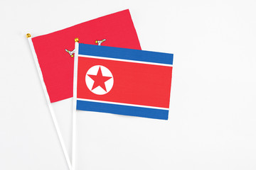 North Korea and Isle Of Man stick flags on white background. High quality fabric, miniature national flag. Peaceful global concept.White floor for copy space.