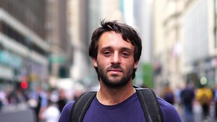 Portrait of young adult man on street in New York. Skateboarder confident guy holding skateboard. Concept of summer in NYC, adventure, healthy living, sport & travel.