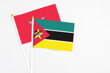 Mozambique and Isle Of Man stick flags on white background. High quality fabric, miniature national flag. Peaceful global concept.White floor for copy space.