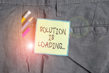 Text sign showing Solution Is Loading. Business photo showcasing thinking of way to solve big problems Diagnoses Writing equipment and green note paper inside pocket of man work trousers