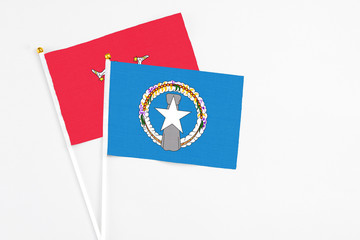 Northern Mariana Islands and Isle Of Man stick flags on white background. High quality fabric, miniature national flag. Peaceful global concept.White floor for copy space.