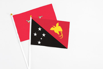 Papua New Guinea and Isle Of Man stick flags on white background. High quality fabric, miniature national flag. Peaceful global concept.White floor for copy space.