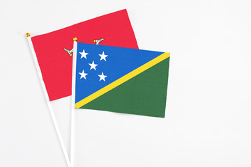 Solomon Islands and Isle Of Man stick flags on white background. High quality fabric, miniature national flag. Peaceful global concept.White floor for copy space.