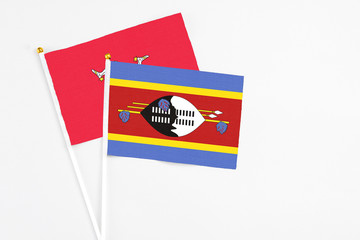 Swaziland and Isle Of Man stick flags on white background. High quality fabric, miniature national flag. Peaceful global concept.White floor for copy space.