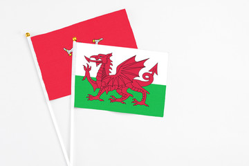 Wales and Isle Of Man stick flags on white background. High quality fabric, miniature national flag. Peaceful global concept.White floor for copy space.