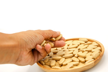 vitamin C pill drug in wood bowl catch by hand on white background