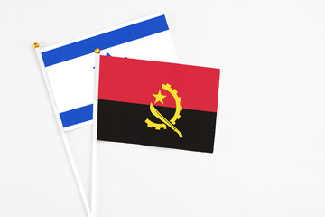 Angola and Israel stick flags on white background. High quality fabric, miniature national flag. Peaceful global concept.White floor for copy space.