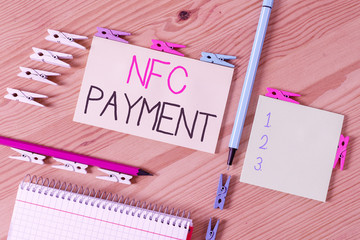 Writing note showing Nfc Payment. Business concept for contactless payment that use nearfield communication technology Colored clothespin papers empty reminder wooden floor background office