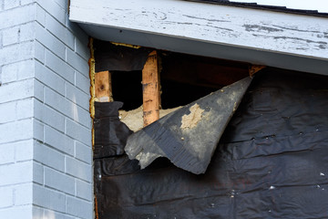 Siding project, outside of house with old siding removed, black weatherproof paper peeling off